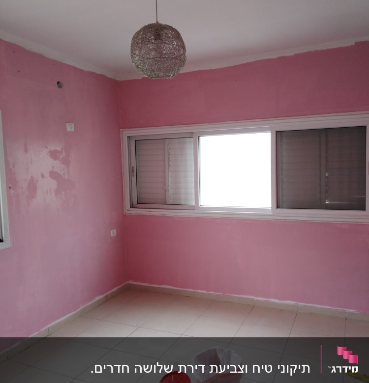 קירות צבועים בוורוד עם דלי צבע על הרצפה